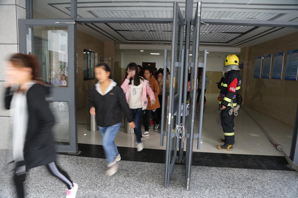 消防官兵指导学生进行消防逃生演练
