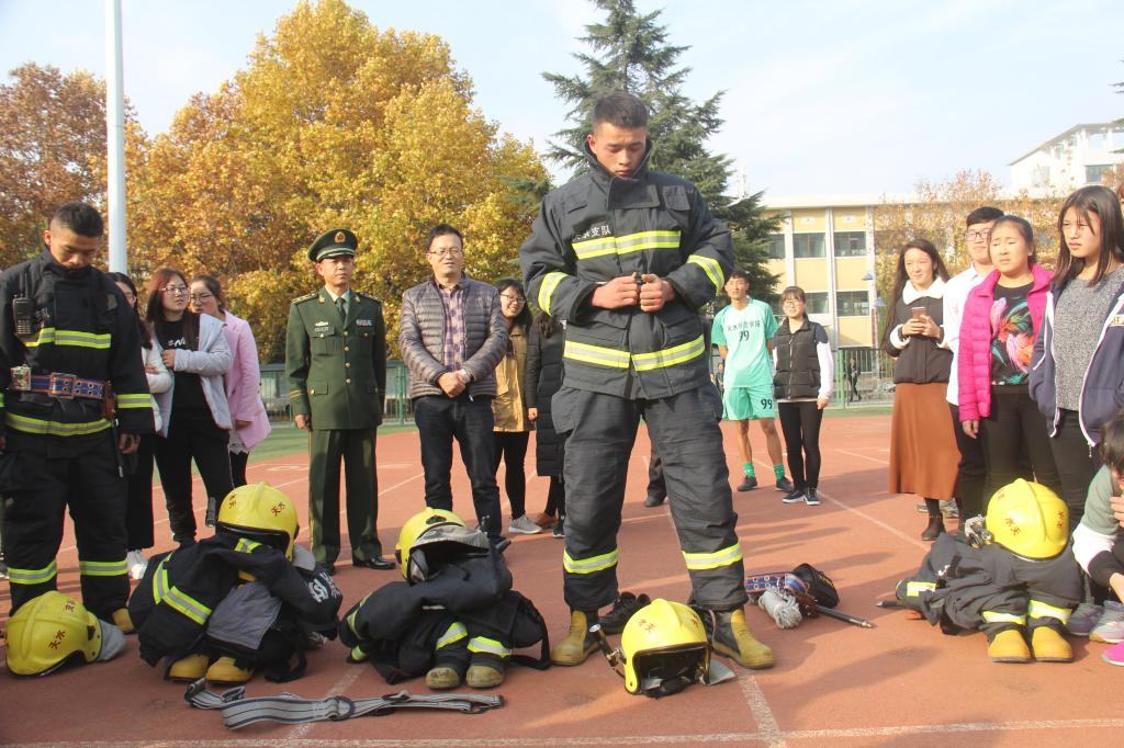 学生身着消防服参与消防演练